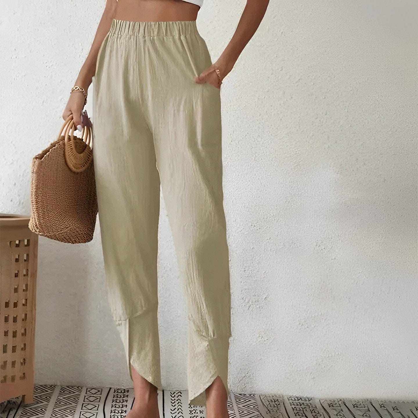 Elegante Damenhose in Beige, kombiniert mit einem geflochtenen Korb. Perfekt für stilvolle Sommermode und lässige Outfits.