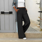 Stilvolle schwarze Freizeithose für Damen, ideal für lässige Outfits. Perfekt kombiniert mit weißem Top und gemustertem Mantel.