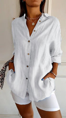 Damenbluse aus Leinen in Weiß, lässig und elegant, mit Knopfleiste und langen Ärmeln. Perfekt für Sommermode und Freizeitoutfits.