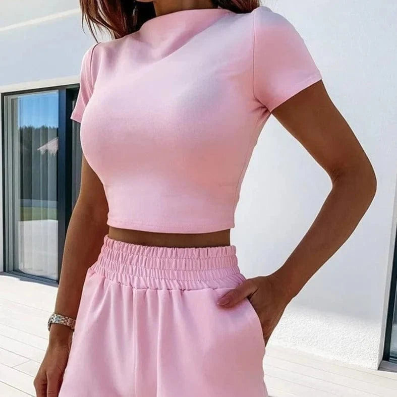 Klassisches Sportset in Rosa für Damen, bestehend aus einem kurzärmeligen Crop-Top und einer bequemen, hoch taillierten Jogginghose. Perfekt für Freizeit und Sport.