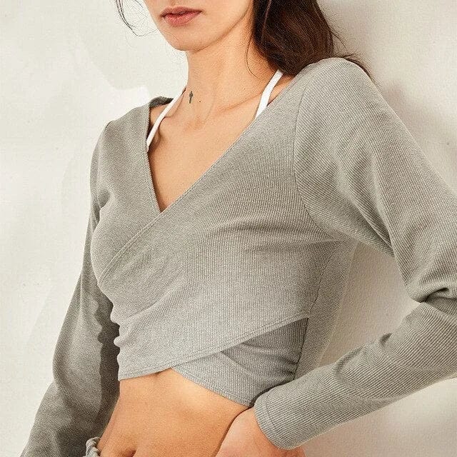 Langärmliges graues Sporttop für Damen, ideal für Fitness und Yoga. Atmungsaktives Material, figurbetontes Design, modisch und bequem.