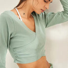 Damen-Sporttop in Grün, langärmlig, aus atmungsaktivem Material. Ideal für Fitness und Yoga. Stilvoll und bequem für aktive Frauen.