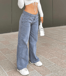 Lässige, modische Jeans mit niedriger Taille, ideal für Streetwear. Perfekt kombiniert mit Crop-Top und Sneakern. Trendige Damenmode 2023.