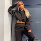 Schwarzer Trainingsanzug mit kurzem Sweatshirt, lässig und modern. Perfekt für Sport und Freizeit. Damenmode, bequem und stylisch.