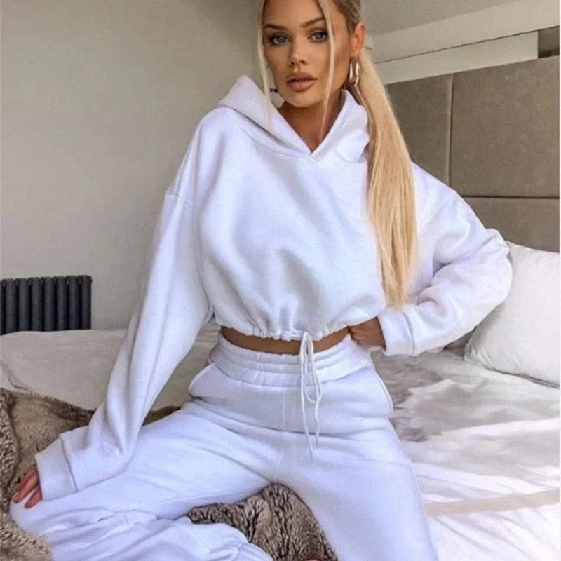 Weißer Trainingsanzug mit kurzem Sweatshirt, ideal für Damenmode. Bequem und stilvoll, perfekt für Freizeit und Sport. Trendige Athleisure-Kleidung.