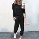 Schwarzes Sweatshirt-Set für Damen, lässig und bequem, ideal für Freizeit und Sport. Perfekt kombiniert mit Sneakers und Handtasche.