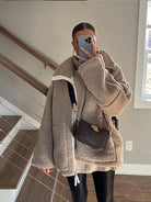 Damen Winterjacke aus Teddyfell, beige, oversized. Perfekt für kalte Tage, kombiniert mit Strickpullover und schwarzer Lederhose. Trendy Wintermode.