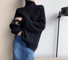 Schwarzer Rollkragenpullover aus Strick, kombiniert mit blauer Jeans. Modetrend, gemütlicher Look, ideal für Herbst und Winter.