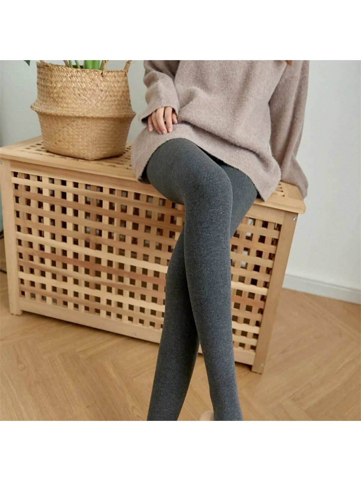 Damen in grauen Strumpfhosen auf Holzbank, gemütlicher Look. Perfekt für Herbstmode, Strickwaren, bequeme Kleidung, stilvolle Outfits.