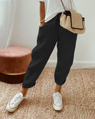 Damen Leinenhose schwarz, lässig, atmungsaktiv, ideal für Sommer, kombiniert mit weißen Sneakers.