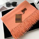 Eleganter orangefarbener Schal mit Fransen von Gerunsi, ideal für Herbstmode. Hochwertiges Accessoire, perfekt für stilvolle Outfits.