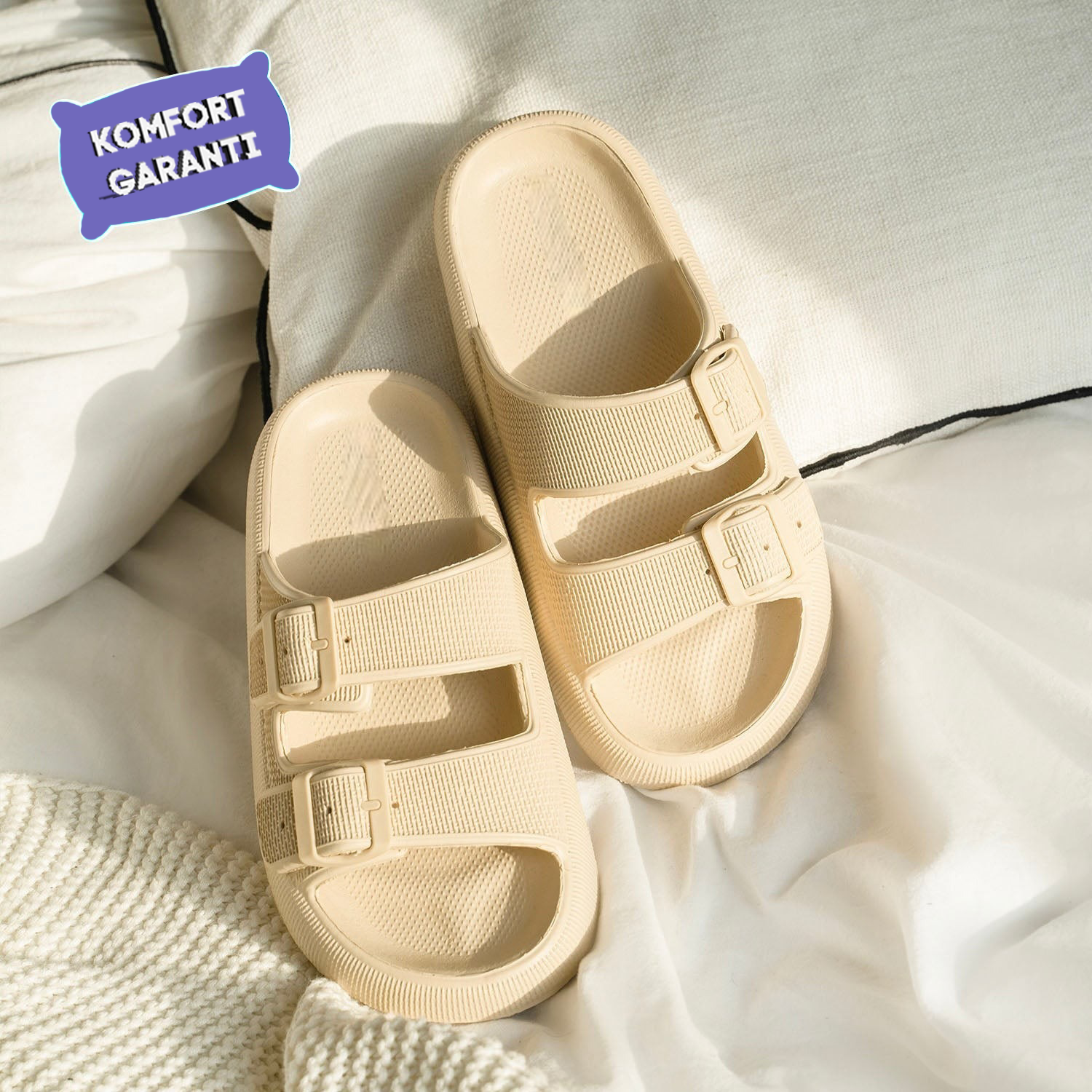 Beige Sandalen mit doppeltem Riemen und Schnallen auf weißem Hintergrund. Komfortable Sommerschuhe, ideal für Strand und Freizeit.