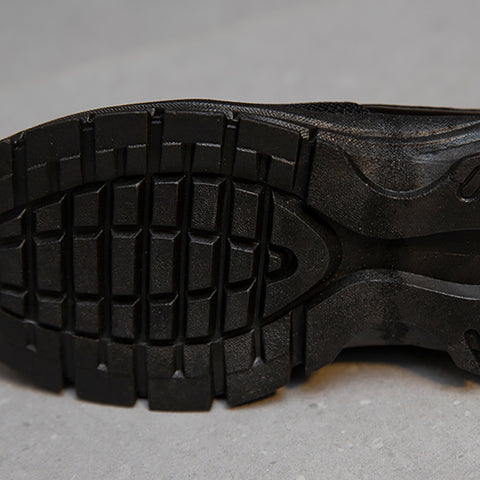 Schwarze Gummisohle mit robustem Profil, ideal für Outdoor-Schuhe. Rutschfest, langlebig, perfekt für Wandern und Trekking.