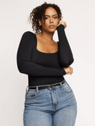 Schwarzer Langarm-Body mit quadratischem Ausschnitt, figurbetont, ideal für Herbstmode. Perfekt kombinierbar mit Jeans für einen eleganten Look.