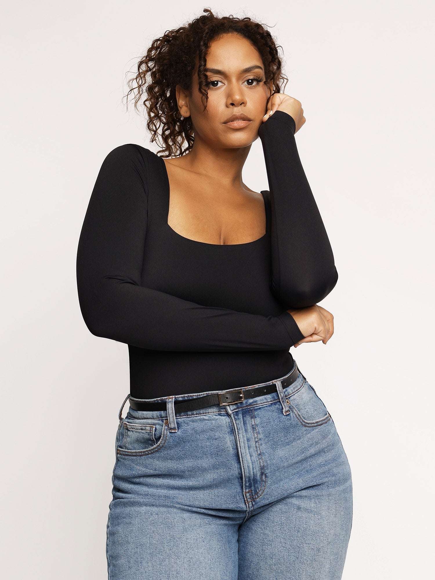 Schwarzer Langarm-Body mit quadratischem Ausschnitt, figurbetont, ideal für Herbstmode. Perfekt kombinierbar mit Jeans für einen eleganten Look.