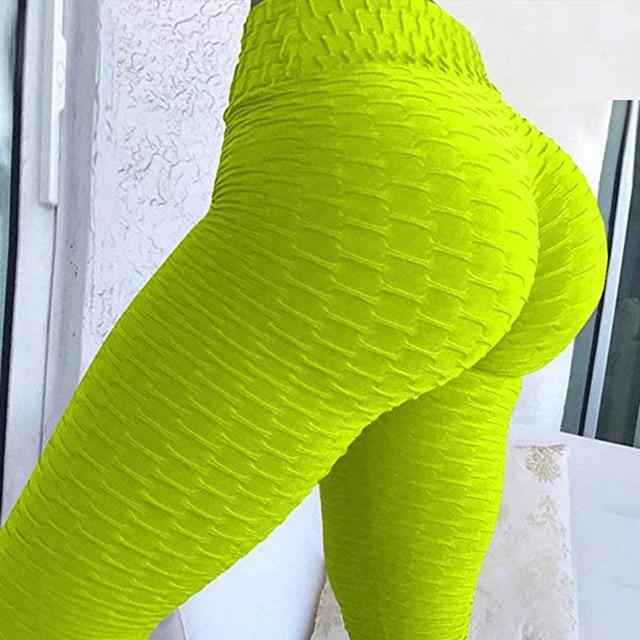 Neon-gelbe Leggings, strukturierter Stoff, figurbetont, modische Damenbekleidung.