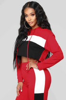 Rotes Damen-Sportset mit Kapuzenpullover und Hose, schwarz-weiße Streifen, modisch, bequem, ideal für Freizeit und Fitness.