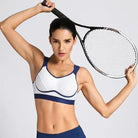 Frau in einem professionellen Sport-BH hält einen Tennisschläger. Ideal für Fitness, Sportbekleidung, Damenmode, aktiver Lebensstil.