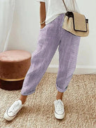 Lila gestreifte Hose, lässig und modisch, kombiniert mit weißem T-Shirt und Sneakers. Perfekt für Sommermode und Freizeitoutfits.