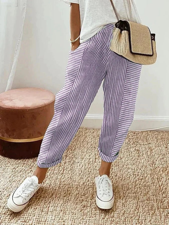Lila gestreifte Hose, lässig und modisch, kombiniert mit weißem T-Shirt und Sneakers. Perfekt für Sommermode und Freizeitoutfits.