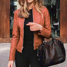 Damen Lederjacke in Braun, modisch und elegant, kombiniert mit schwarzer Handtasche. Perfekt für Herbstmode und stilvolle Outfits.
