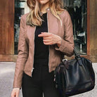 Damen-Lederjacke in Beige, modisch und elegant, kombiniert mit schwarzer Handtasche. Perfekt für stilvolle Herbst- und Winteroutfits.