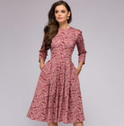 Elegantes, mittellanges Kleid in Rosa mit floralem Muster, 3/4-Ärmeln und tailliertem Schnitt. Perfekt für stilvolle Anlässe und Modebewusste.