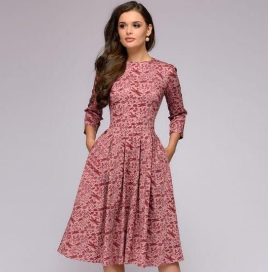 Elegantes, mittellanges Kleid in Rosa mit floralem Muster, 3/4-Ärmeln und tailliertem Schnitt. Perfekt für stilvolle Anlässe und Modebewusste.