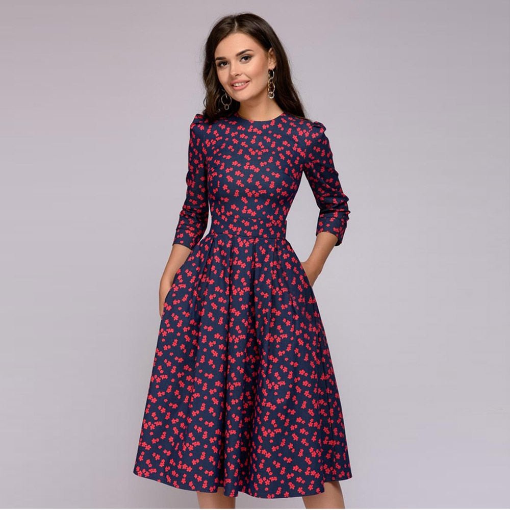 Elegantes, mittellanges Kleid mit roten Blumenmuster, 3/4-Ärmeln und tailliertem Schnitt. Perfekt für Retro-Mode und stilvolle Anlässe.