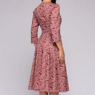 Elegantes, mittellanges Kleid in Rot mit floralem Muster, 3/4-Ärmeln und tailliertem Schnitt. Perfekt für stilvolle Anlässe und Retro-Looks.