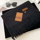 Schwarzer Schal mit Fransen, stilvoll und elegant, aus weichem Material. Perfekt für Herbst und Winter. Ideal als modisches Accessoire.