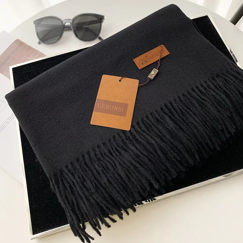Schwarzer Schal mit Fransen, stilvoll und elegant, aus weichem Material. Perfekt für Herbst und Winter. Ideal als modisches Accessoire.