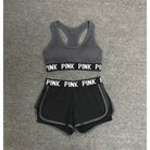 Graues Sportset für Damen mit "PINK" Schriftzug, bestehend aus Sport-BH und Shorts. Ideal für Fitness, Yoga und Laufen. Bequem und stylisch.