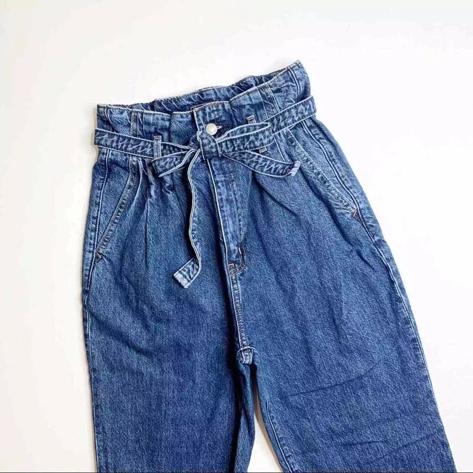 Damen-Jeans mit Paperbag-Taille, blauer Denim, hoher Bund, modischer Gürtel, lässiger Stil, ideal für trendige Outfits und bequemen Alltagslook.