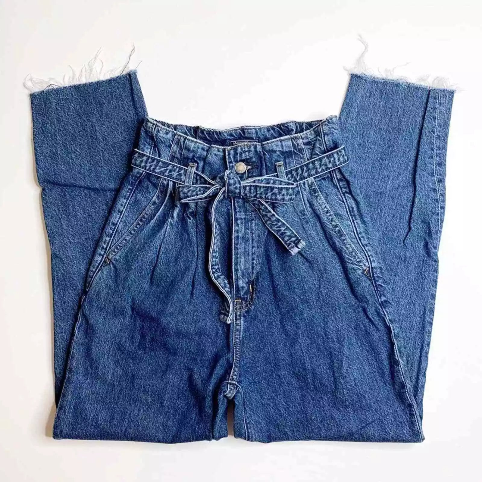 Hoch taillierte Damen-Jeansshorts aus blauem Denim mit Paperbag-Bund und Bindegürtel. Modische Sommerbekleidung, lässiger Stil.