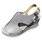 Silberne Damen-Sandale mit Keilabsatz, Glitzer-Design und verstellbarem Riemen. Perfekt für Sommermode und elegante Anlässe.