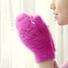 Flauschige pinke Handschuhe halten eine Tasse. Perfekt für kalte Wintertage. Modisch, warm und kuschelig. Ideal für Damenmode im Winter.