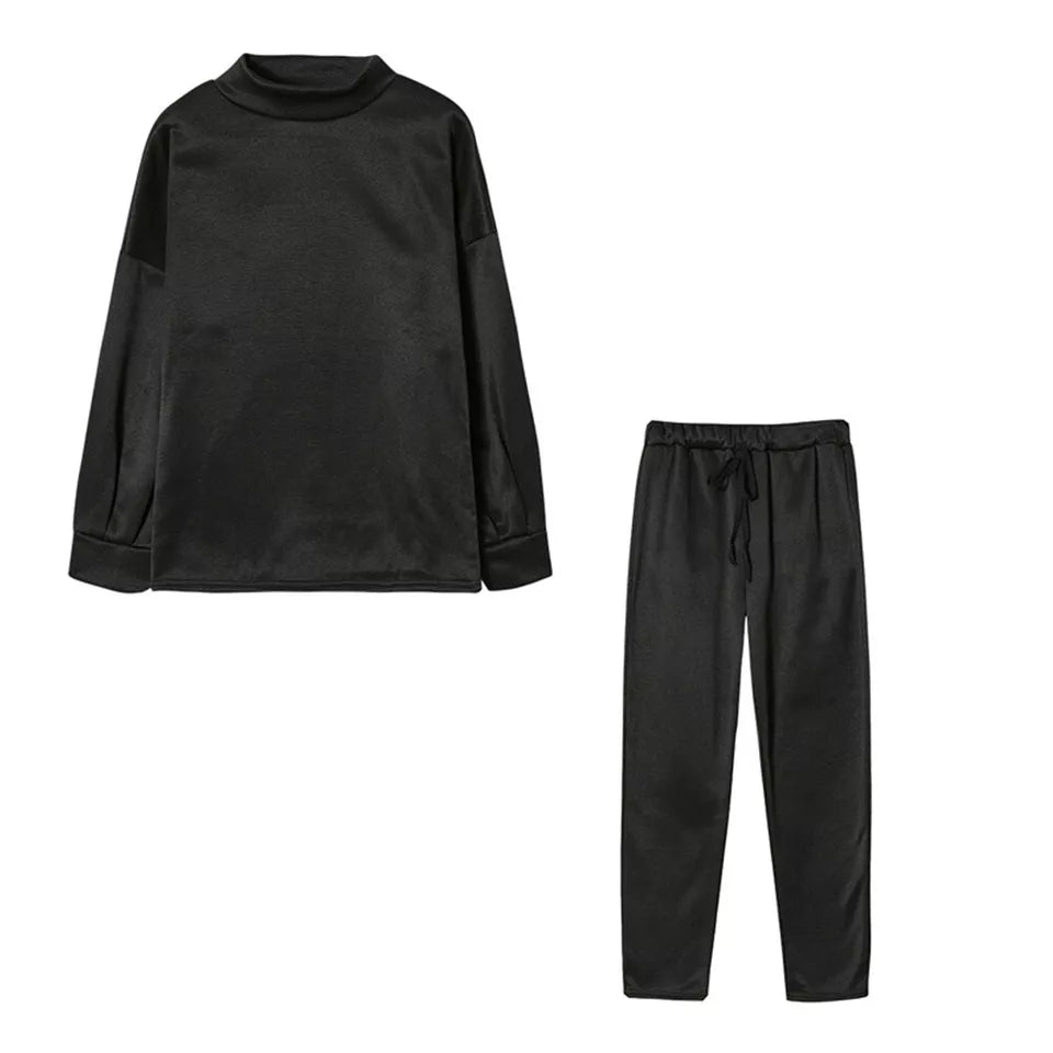 Schwarzer Damen-Pyjama-Set aus Satin, bestehend aus langärmligem Oberteil und Hose. Bequem, elegant, ideal für Nachtwäsche und Lounge.