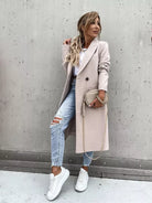 Eleganter Damenmantel in Beige, kombiniert mit zerrissenen Jeans und weißen Sneakers. Perfekt für modische Herbst-Looks. Trendige Damenmode.