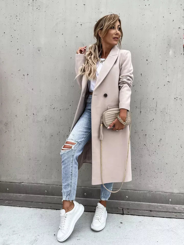 Eleganter Damenmantel in Beige, kombiniert mit zerrissenen Jeans und weißen Sneakers. Perfekt für modische Herbst-Looks. Trendige Damenmode.