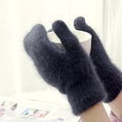 Weiche, flauschige schwarze Handschuhe halten eine Tasse. Perfekt für kalte Wintertage. Modische Accessoires, warme Handschuhe, Wintermode.