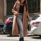 Eleganter Wintermantel in Kamelhaarfarbe, kombiniert mit schwarzem Oberteil und grauer Jeans. Perfekt für stilvolle Wintermode und urbane Eleganz.