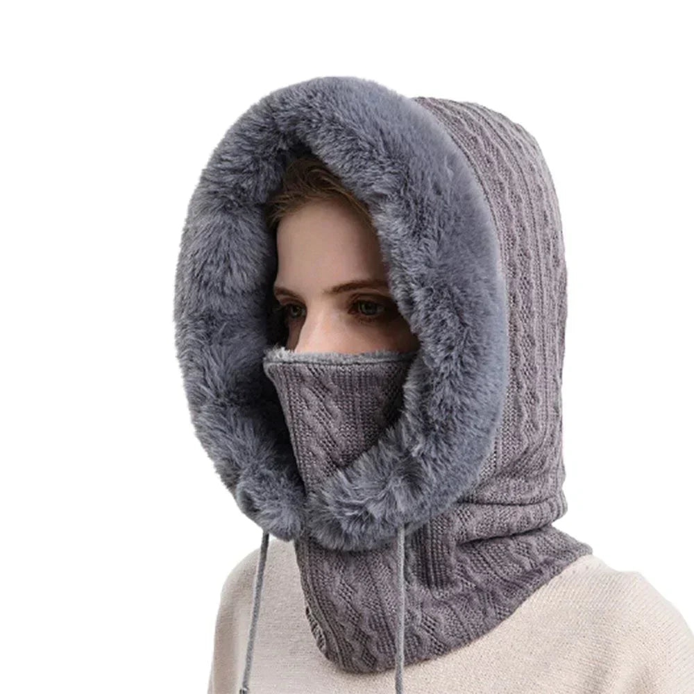 Gestrickte Kapuzenmütze mit Kunstfellbesatz in Grau, ideal für Wintermode. Warm, stilvoll und vielseitig einsetzbar für kalte Tage.