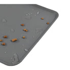Rutschfeste, wasserdichte Silikon-Futtermatte für Hunde in Grau mit Futterstücken.