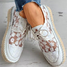 Stilvolle, luftige Damenschuhe mit Blumenmuster, ideal für den Sommer. Bequeme, modische Sneaker mit weißem Spitzen-Design und Bastsohle.