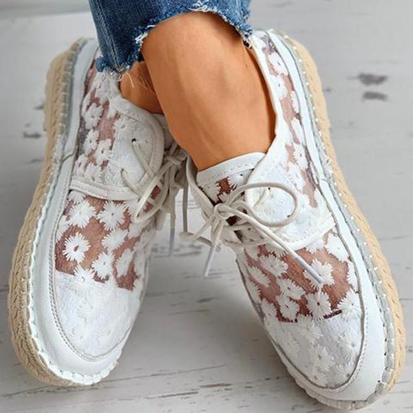 Stilvolle, luftige Damenschuhe mit Blumenmuster, ideal für den Sommer. Bequeme, modische Sneaker mit weißem Spitzen-Design und Bastsohle.