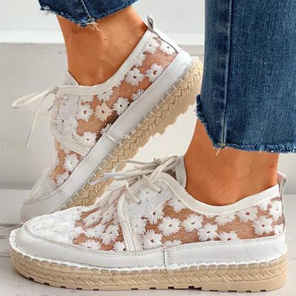 Stilvolle, luftige Damenschuhe mit Blumenmuster, ideal für den Sommer. Bequeme Sneaker mit weißem Spitzen-Design und geflochtener Sohle.