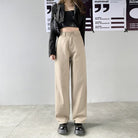 Damen-Jeans mit geradem Bein und hoher Taille in Beige, kombiniert mit schwarzem Crop-Top und Blazer. Modetrend, lässiger Streetstyle-Look.