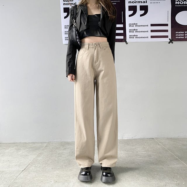 Damen-Jeans mit geradem Bein und hoher Taille in Beige, kombiniert mit schwarzem Crop-Top und Blazer. Modetrend, lässiger Streetstyle-Look.
