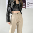 Damen-Jeans mit geradem Bein und hoher Taille in Beige, kombiniert mit schwarzer Jacke und Top. Modetrend, lässiger Stil, Streetwear.